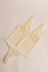 Topcito tipo bralette de encaje negro con escote en V profundo y tirantes anchos. El encaje es elastizado para un ajuste cómodo.