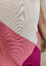 Vestido midi de tejido de punto en bloques de color blanco, rosado y fucsia, sin mangas, con cuello redondo y tajo lateral.