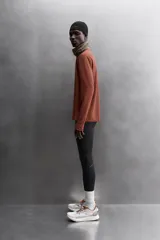 Camiseta deportiva color durazno de manga larga con orificios para los pulgares.