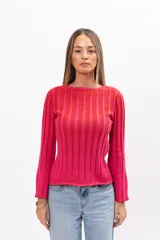 Buzo de punto acanalado con diseño de rayas verticales en tonos fucsia y rojo, de corte ajustado, cuello redondo y mangas largas ligeramente acampanadas.