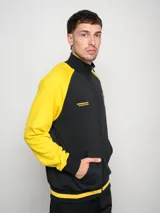 Campera deportiva de felpa negra con mangas amarillas en contraste y escudo del Club Atlético Peñarol estampado en el pecho.