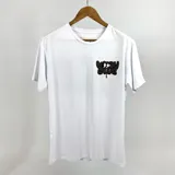 Remera blanca de algodón con estampado en el pecho y en la espalda con la frase "Moody Club" en letras negras con contorno beige.