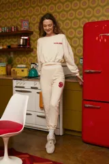 Pantalón de jogging color crema con logo de los Rolling Stones en rojo en la pierna.