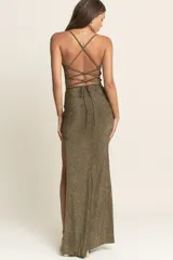 Vestido largo de lurex con acabado brillante, corte ajustado al cuerpo, escote recto con breteles finos y tajo lateral profundo en la falda.