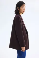 Blazer de sarga color bordó con solapas de pico, frente abierto y bolsillos delanteros ribeteados con solapa.