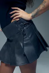 Minifalda tableada de cuero sintético con cintura ancha y cierre lateral con cordones.