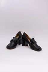 Zapato de cuero rojo con aplique decorativo en el empeine y tacón cuadrado.