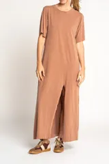 Vestido largo color visón de algodón con cuello redondo y mangas cortas. Presenta un tajo alto en el frente.