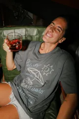 Remera oversize color gris oscuro con estampa frontal en tonos claros que incluye un carrito de helados, una sombrilla y el texto 'Palito Bombón Helado' junto a la firma de la colaboración Pica x Petrichor.