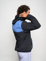 Canguro negro con capucha y medio cierre, marca Umbro, modelo Urban. Detalles en azul en el logo, interior de la capucha y ribete de los bolsillos.