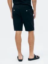 Bermuda de gabardina color beige con cintura elástica y cordón ajustable. Presenta bolsillos laterales y ruedo con dobladillo.