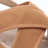 Sandalias de mujer color beige con plataforma blanca. Presentan tiras anchas cruzadas en el empeine, una de ellas de tejido de punto. Cuentan con tira ajustable en el talón.