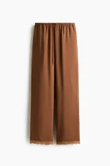 Pantalón de pierna recta color marrón con leve brillo, cintura elástica con cordón ajustable y ribetes de encaje en los bajos.