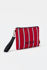 Neceser tipo pouch de neopreno con estampa de rayas rojas y celestes, cierre superior y correa de mano negra extraíble.