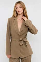 Blazer color tostado de corte relajado, con solapas de muesca, mangas largas y un lazo ajustable para atar en la cintura.