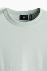 Remera verde claro de corte holgado, cuello redondo y manga corta. Confeccionada con tejido funcional COOLMAX®, una fibra de poliéster de secado rápido que elimina la humedad y regula la temperatura corporal.