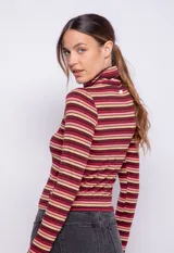 Polera de manga larga con cuello alto, confeccionada en tejido de punto con diseño de rayas horizontales en blanco y negro.