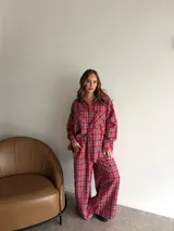 Conjunto de dos piezas compuesto por camisa de manga larga con botones y pantalón de corte recto y holgado, ambos confeccionados en tela de viyela con estampado de cuadros en tonos blanco y negro.