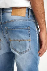 Jean celeste con efecto lavado y roturas en las rodillas, de corte ajustado.