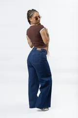 Pantalón de jean azul oscuro, tiro alto, de corte ancho (wide leg) y largo.