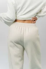 Pantalón deportivo de corte wide leg con caída relajada. Presenta cintura elastizada con cordón ajustable, bolsillos laterales y un interior frizado para mayor abrigo.