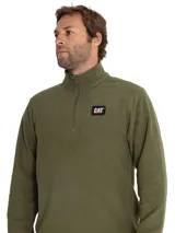 Buzo de microfleece color verde oliva, con cuello alto y cierre frontal parcial. Presenta el logo de la marca Caterpillar en un parche rectangular en el pecho.