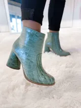 Bota corta color verde agua con textura croco, punta redonda y taco forrado a tono.
