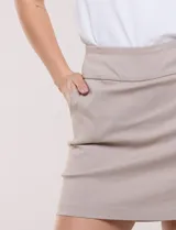 Falda tipo skort de gabardina elastizada color marrón, corte mini con pretina ancha, bolsillos frontales funcionales y short interno incorporado para mayor comodidad.