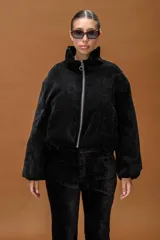 Campera tipo bomber de textura aterciopelada, con cuello alto estructurado y cierre frontal con cremallera metálica.