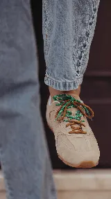 Zapatillas urbanas de cuero celeste y mesh gris, con suela de goma y doble juego de cordones intercambiables en color verde y blanco.