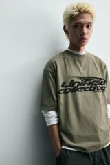 Camiseta de algodón con corte relajado, cuello redondo y manga corta. Presenta un estampado gráfico frontal en color negro con tipografía estilo deportivo y efecto desgastado.