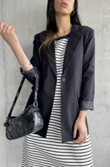 Blazer negro de lino con solapas de muesca, cierre con un botón y bolsillos delanteros.