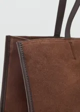 Bolso tipo shopper de piel de serraje en color marrón, con diseño de paneles y doble asa de hombro. Cuenta con cierre de botón magnético y bolsillo interior con cremallera.