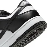 Championes Nike modelo Dunk Low Retro, en colores blanco y negro, confeccionados en cuero sintético, con diseño clásico de perfil bajo, suela de goma y cordones al tono.