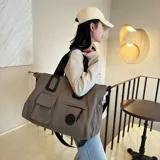 Bolso deportivo multifunción color negro, con diseño liso, compartimento principal con cierre, bolsillo frontal con solapa y bolsillo frontal con cierre. Cuenta con doble asa de mano y correa de hombro ajustable y extraíble. Incluye detalle de logo circular en la parte inferior.