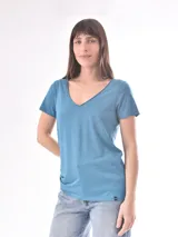 Remera blanca de manga corta con escote en V, de tejido ligero y ligeramente traslúcido.