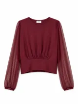 Blusa color bordó con cuerpo de tela opaca y mangas largas translúcidas de tul con efecto abullonado en los puños, con detalle fruncido en la parte frontal de la cintura.