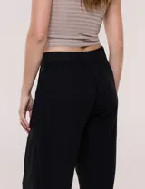 Pantalón crop de lino y rayón, con diseño wide leg de corte holgado, estampado tropical de hojas en tonos verde, azul y marrón sobre fondo blanco. Cuenta con pretina trasera elastizada y bolsillos delanteros.