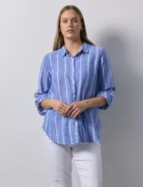 Camisa de lino de la marca Dash, con diseño a rayas verticales en tonos azul y blanco. Presenta cuello camisero, cierre frontal con botones, mangas largas con puños regulables mediante presilla y botón, y un bolsillo aplicado en el pecho.