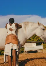 Falda corta de cuero en tono marrón con acabado desgastado, presenta bolsillos laterales grandes e irregulares y costuras decorativas visibles.