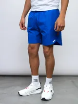 Short deportivo azul con escudo del Club Nacional de Football en la pierna derecha y detalles tricolor.