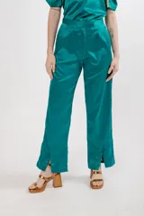Pantalón de seda color verde esmeralda, de tiro alto, corte recto, con pinzas en la pretina y tajos en el ruedo.