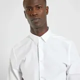 Camisa blanca de corte recto, con cuello clásico y mangas largas.