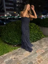 Vestido largo de fiesta color azul marino con estampado de lunares blancos, diseño strapless con frunces laterales y tajo frontal pronunciado.