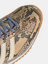 Championes Adidas SL 72 OG de perfil bajo, con empeine de cuero con estampado de piel de serpiente, tres tiras blancas laterales, cordones celestes y suela de goma estriada con entresuela de EVA y detalle en celeste.