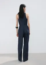 Mono largo de denim color azul oscuro, con escote halter y diseño recto en las piernas.