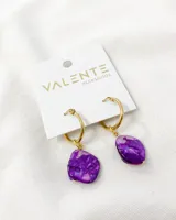 Aros colgantes con aro dorado de acero y dije de piedra nacarada violeta.