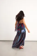 Vestido largo sin mangas, con escote halter y abertura en el pecho, corte holgado y diseño combinado de estampa abstracta floral en la parte superior y rayas verticales traslúcidas en la falda.