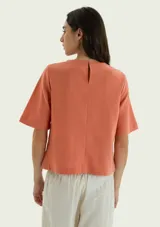 Blusa de manga corta color celeste, con cuello redondo y diseño holgado.