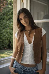 Chaleco de cuero color marrón, con diseño artesanal que presenta tientos pasados a mano en todo su contorno. Es una prenda de corte clásico y estructura abierta.